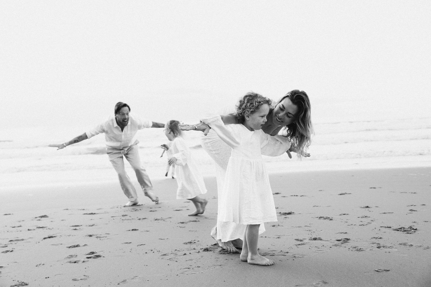 Family Photography - Candid image of big family playing airplanes at Bilgola Beach, Northern Beaches, Sydney