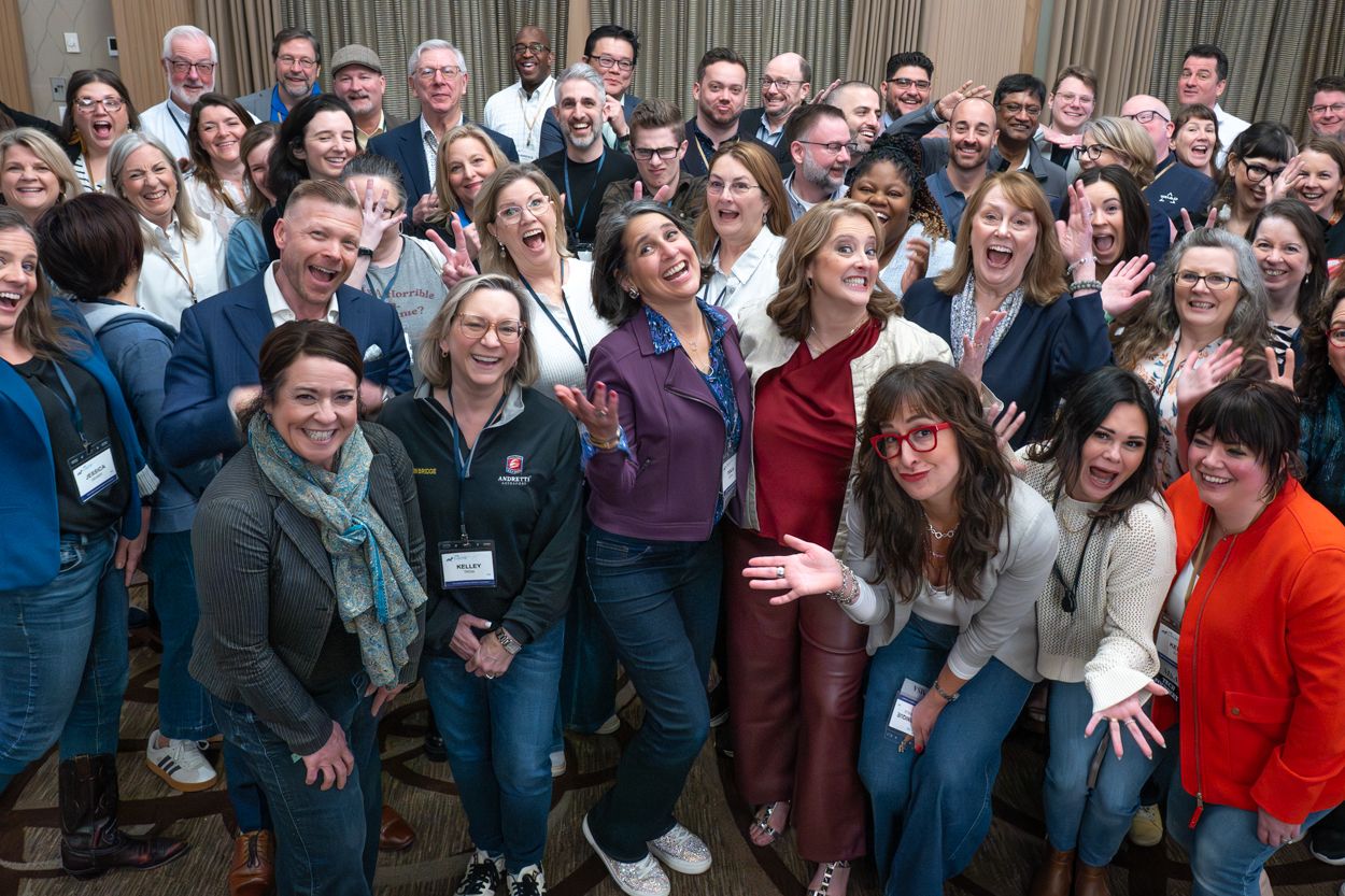 Large group of diverse professionals smiling and posing together at a corporate networking event or conference.