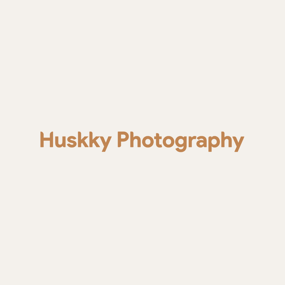 Simple text logo for Huskky Photography in brown lettering against a light beige background.