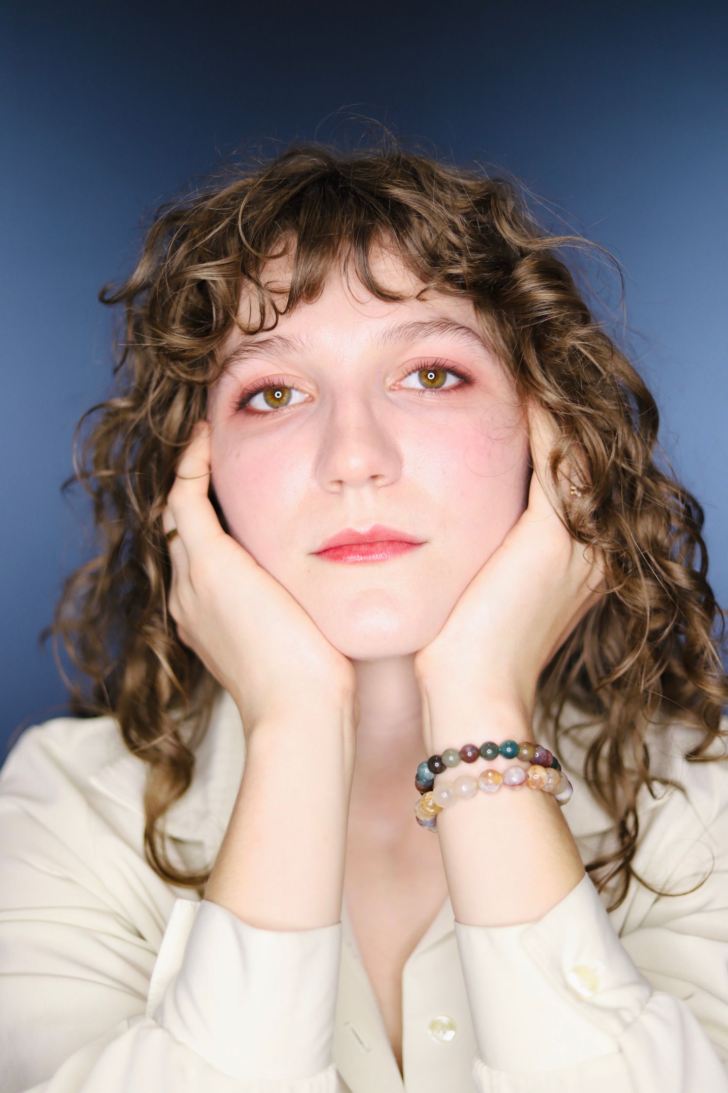 Whimsical portrait series in white sweater with playful expressions.