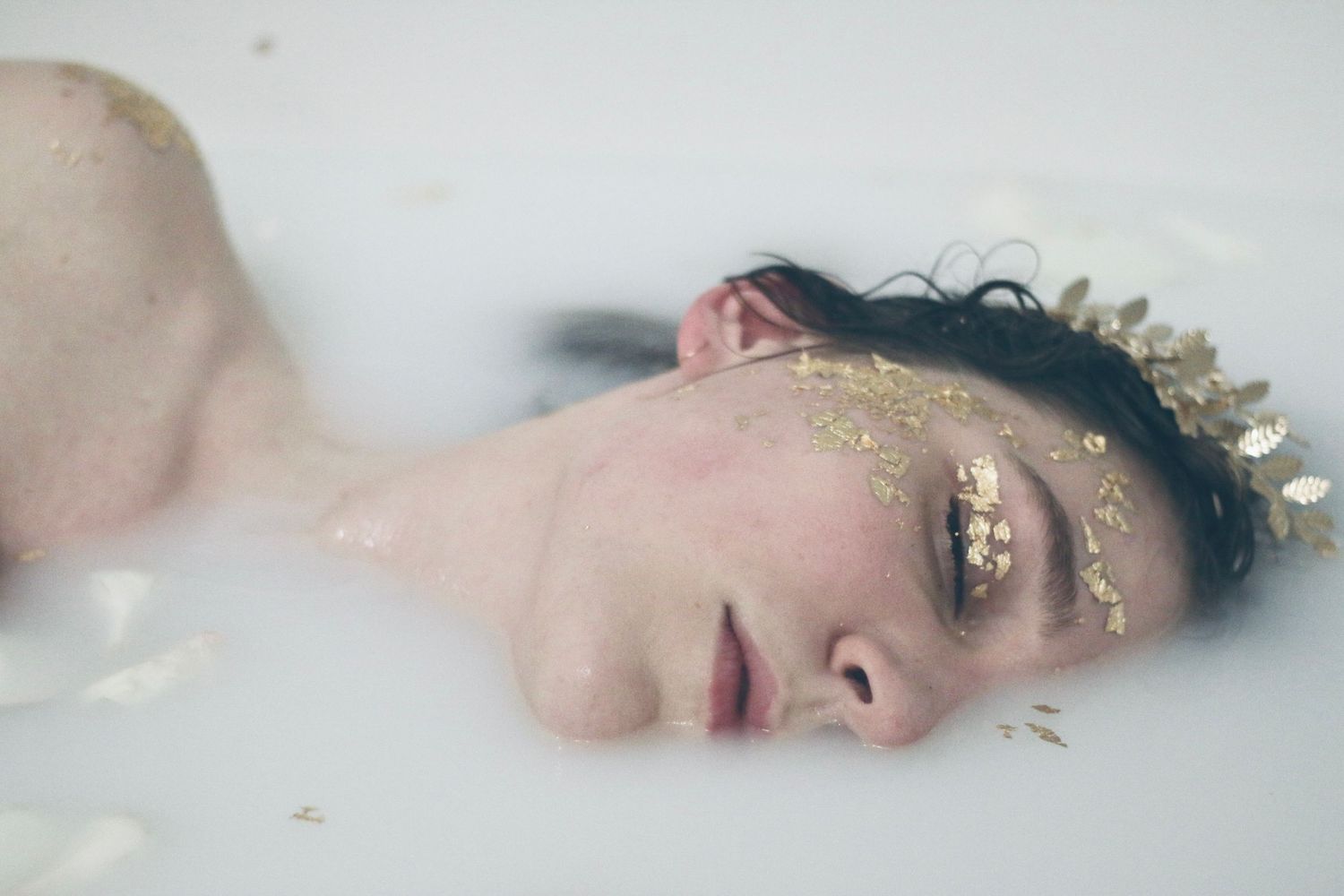Ethereal portrait in milky water with gold accents and crown details.