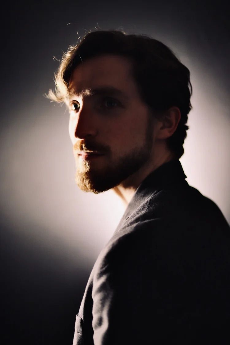 Artistic side profile silhouette with dramatic rim lighting highlighting facial features and beard.