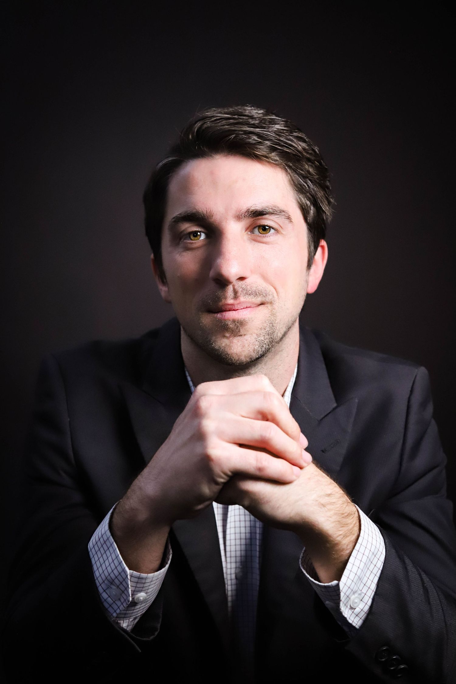 Professional portrait series showing contemplative poses against dark background in business attire.