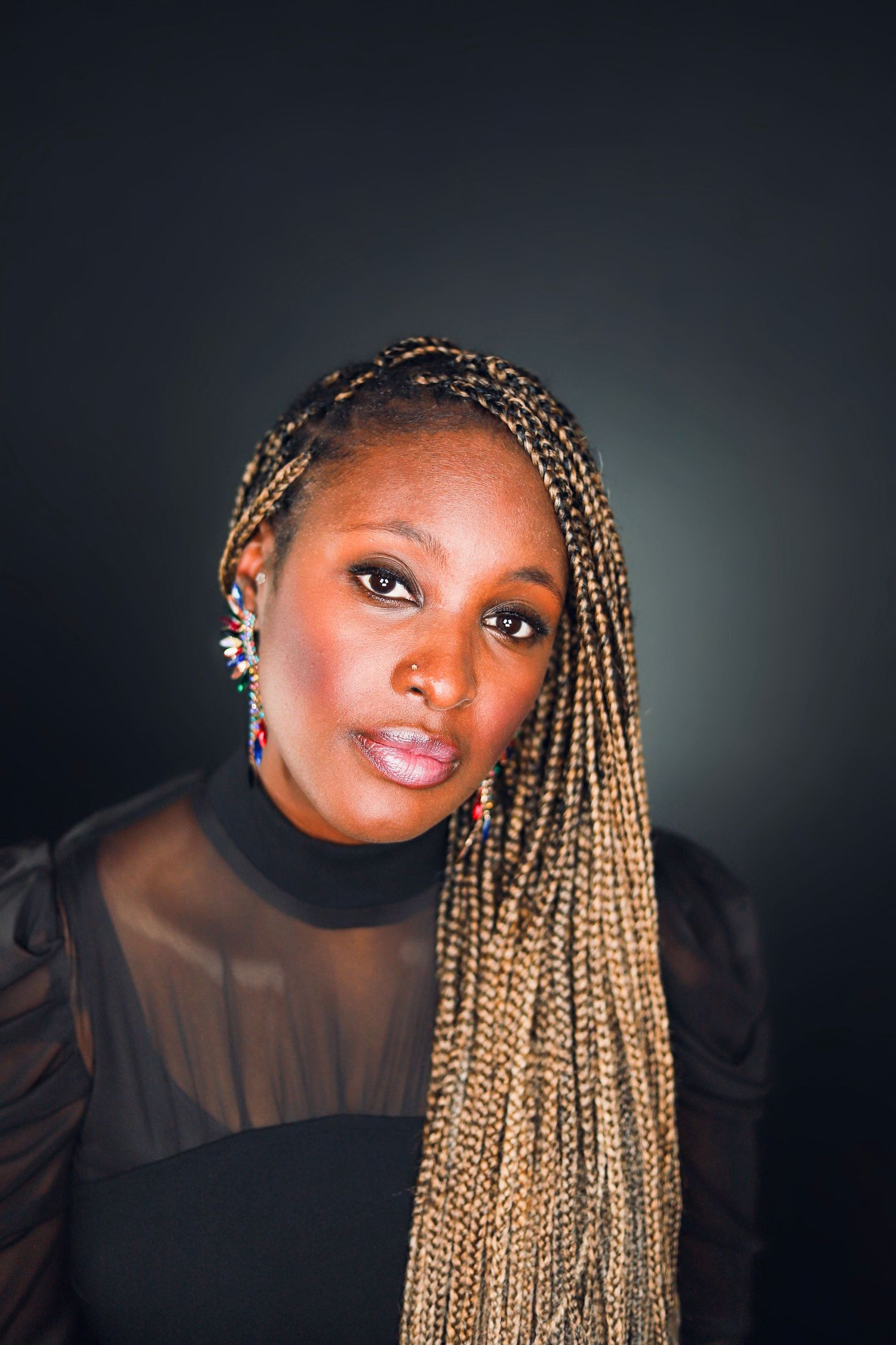A portrait series showing a figure with blonde box braids wearing a black sheer top against a dark background.