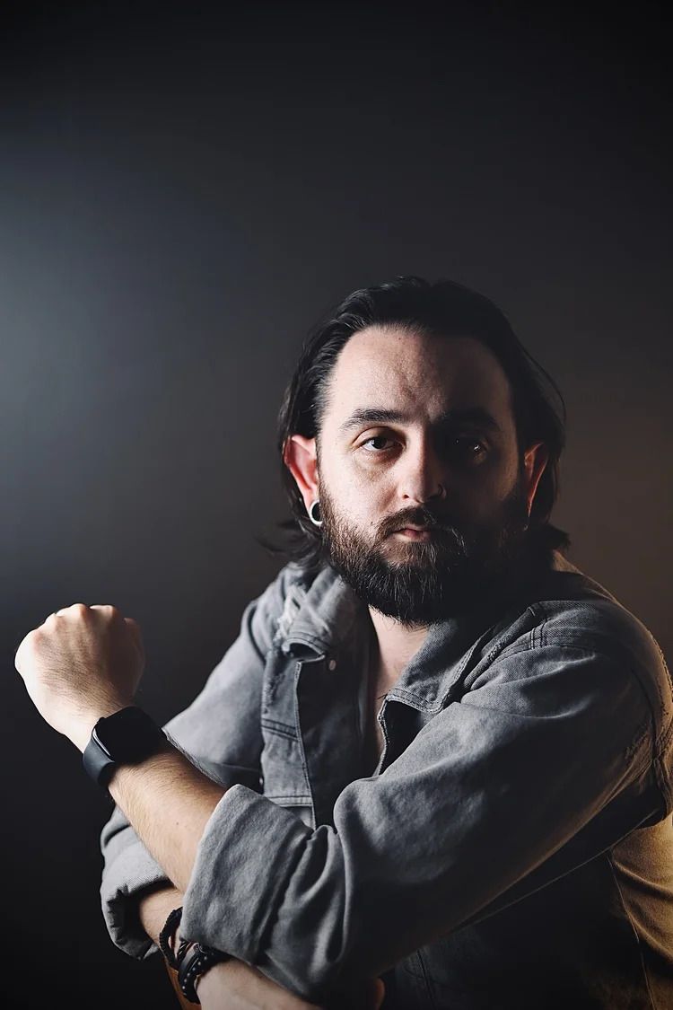 Artistic portrait series showing dramatic shadows and expressions in dark setting.