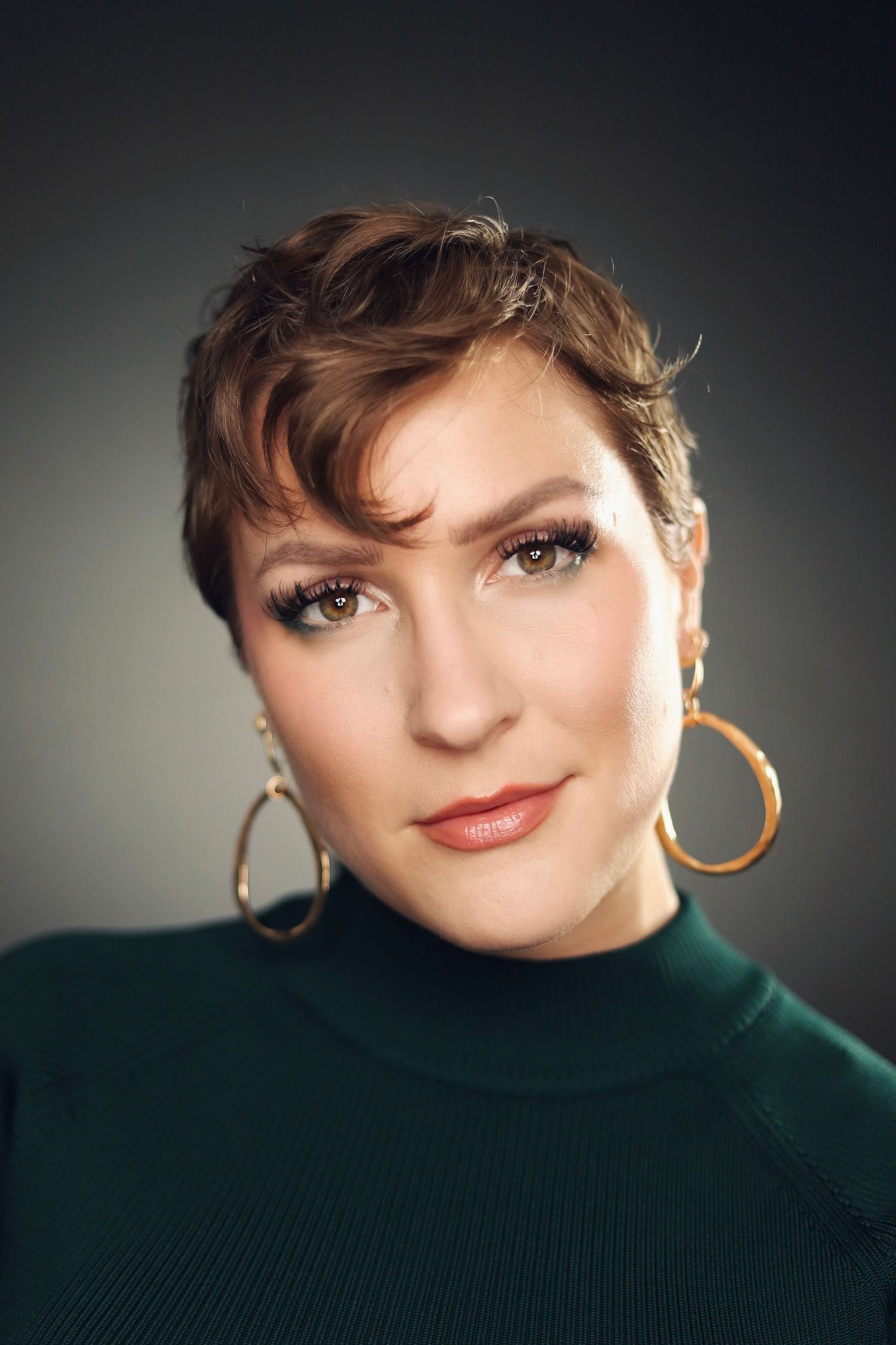 Stylish portraits featuring short hair, hoop earrings and turtleneck sweater with dramatic lighting.
