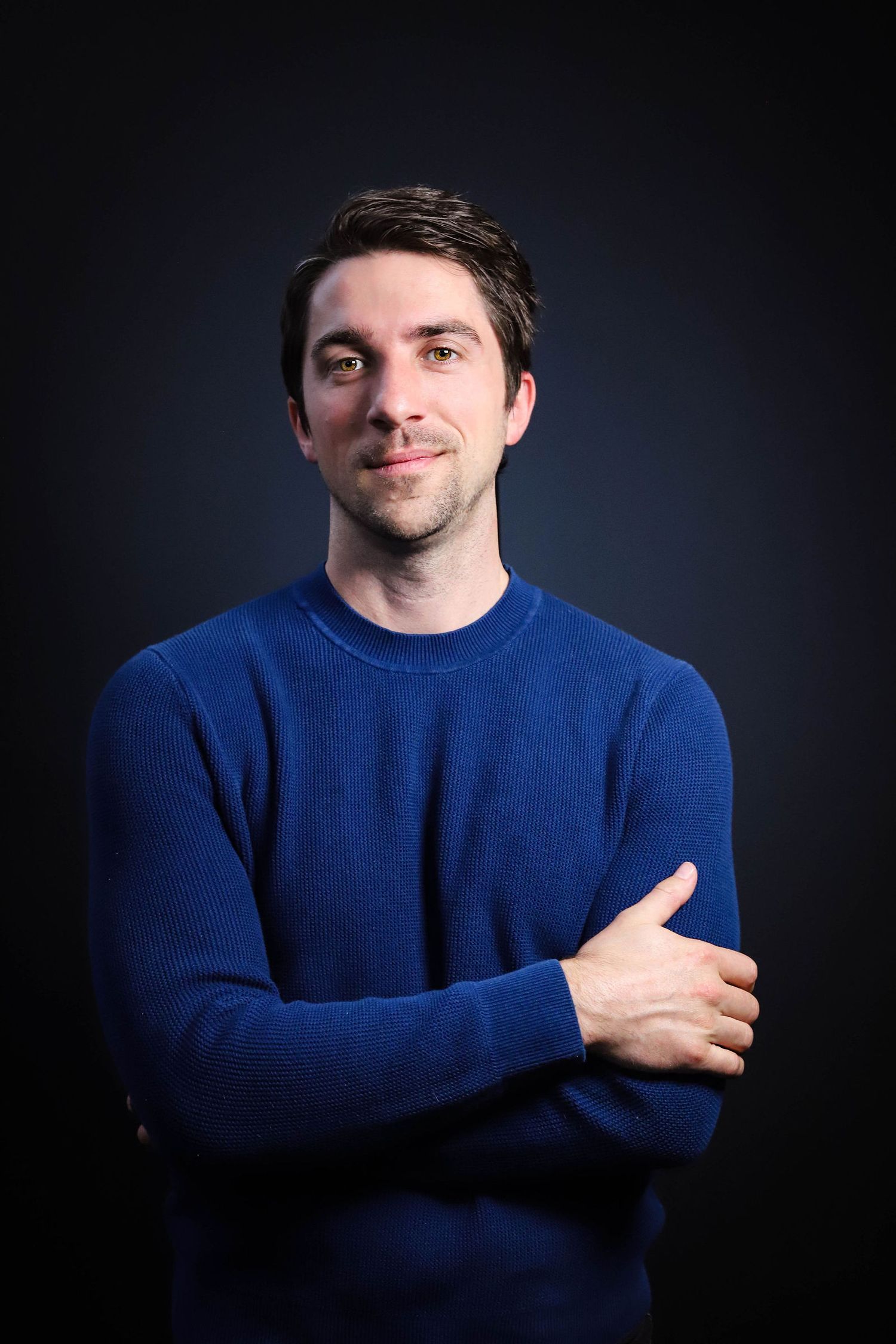 Portrait series showing someone in a blue sweater against dark background making expressive gestures.