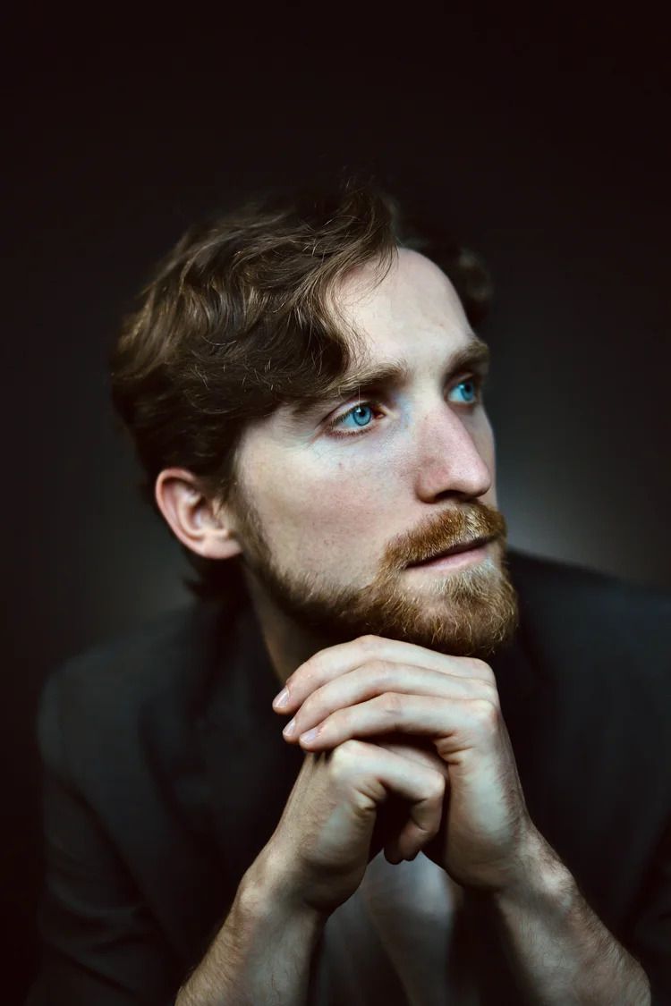 Artistic portraits highlighting bright blue eyes and ginger beard in low-key lighting.