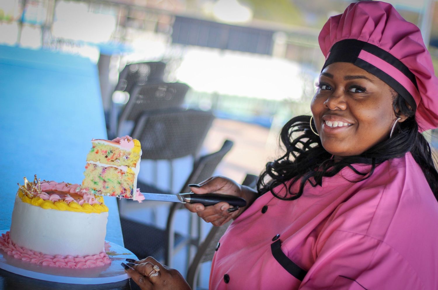 Branding portrait of a cake decorator smiling while presenting a custom cake during a professional photoshoot by Pctr Me Photography