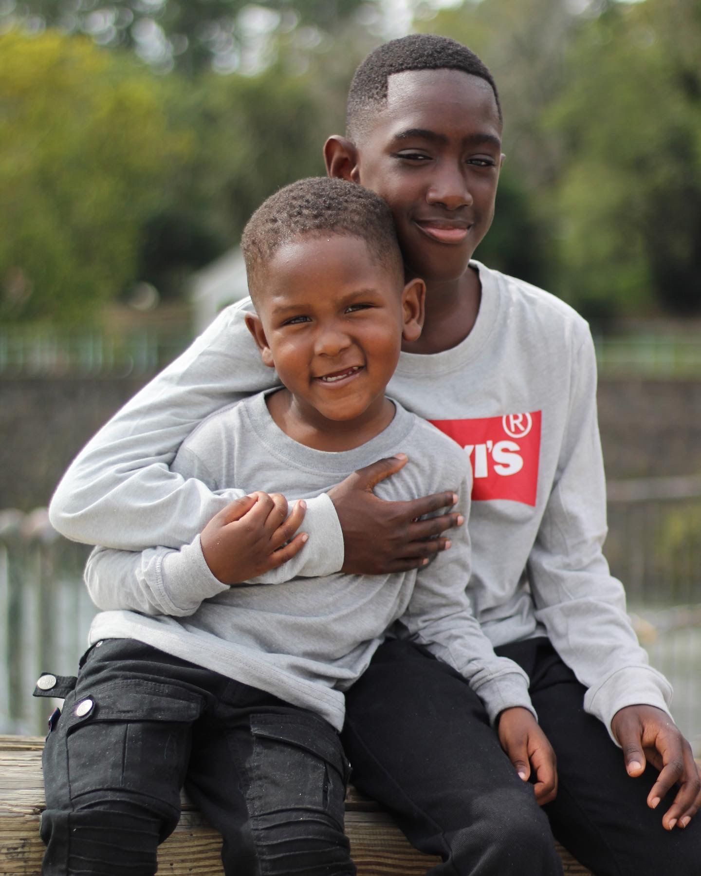 Portrait of two brothers sitting together outdoors, capturing joy, connection, and sibling bonds