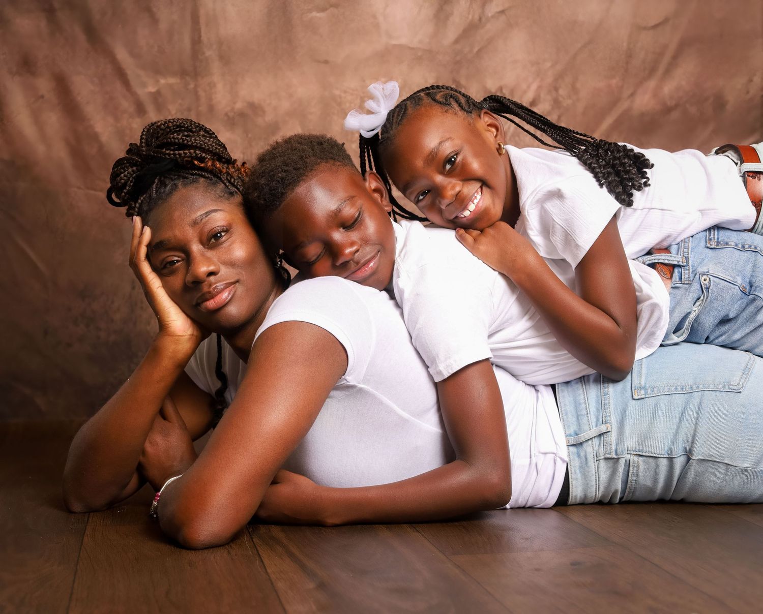 Mother and children lying together during a family portrait session capturing closeness and love