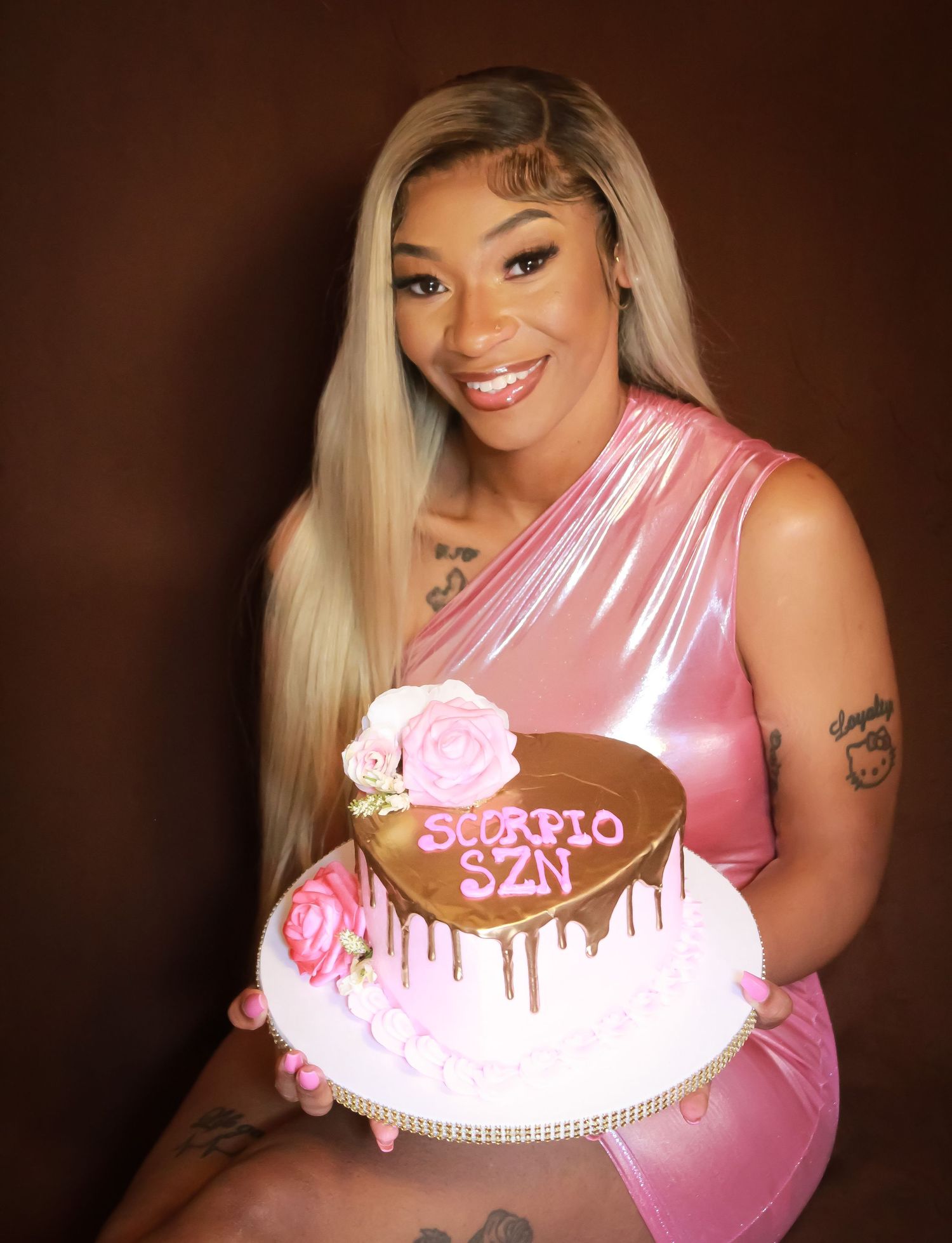 Birthday portrait of a woman holding a custom cake during a styled celebration photoshoot