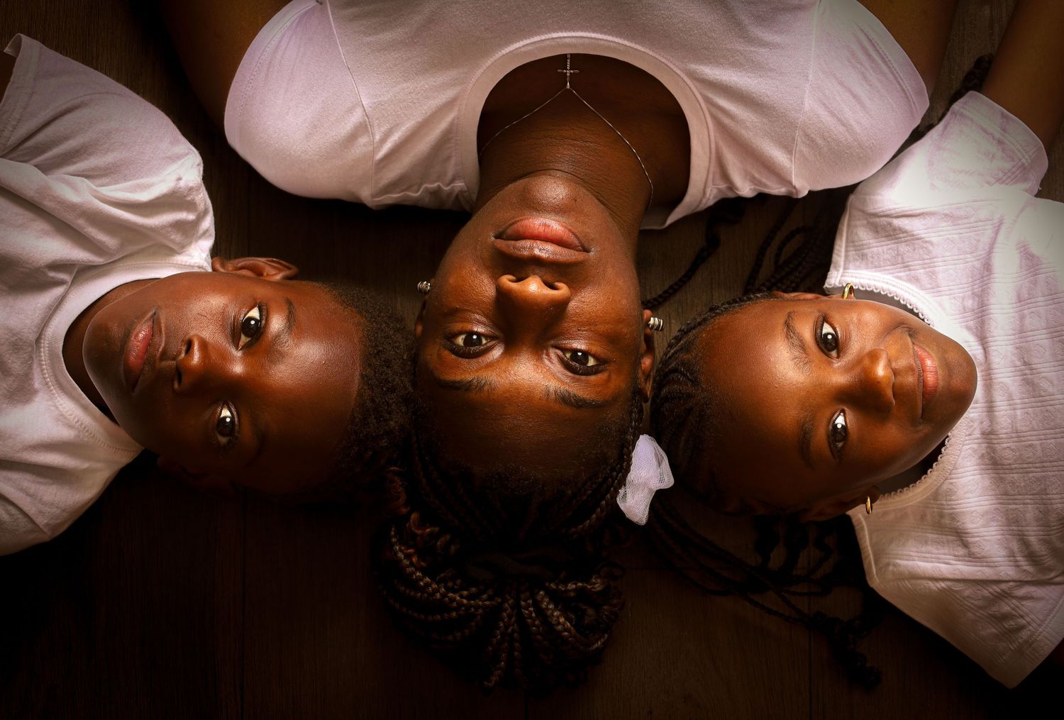 Creative family portrait of a mother and her children lying close together, capturing connection, warmth, and family bonds