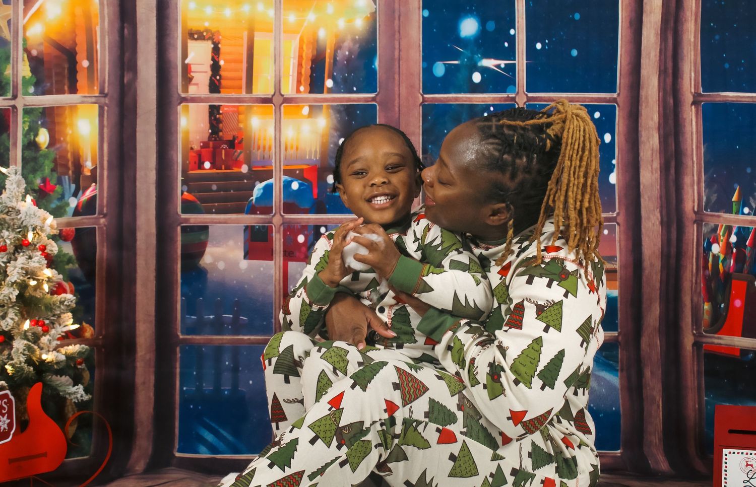 Mother sharing a joyful holiday moment with her child during a festive family portrait session