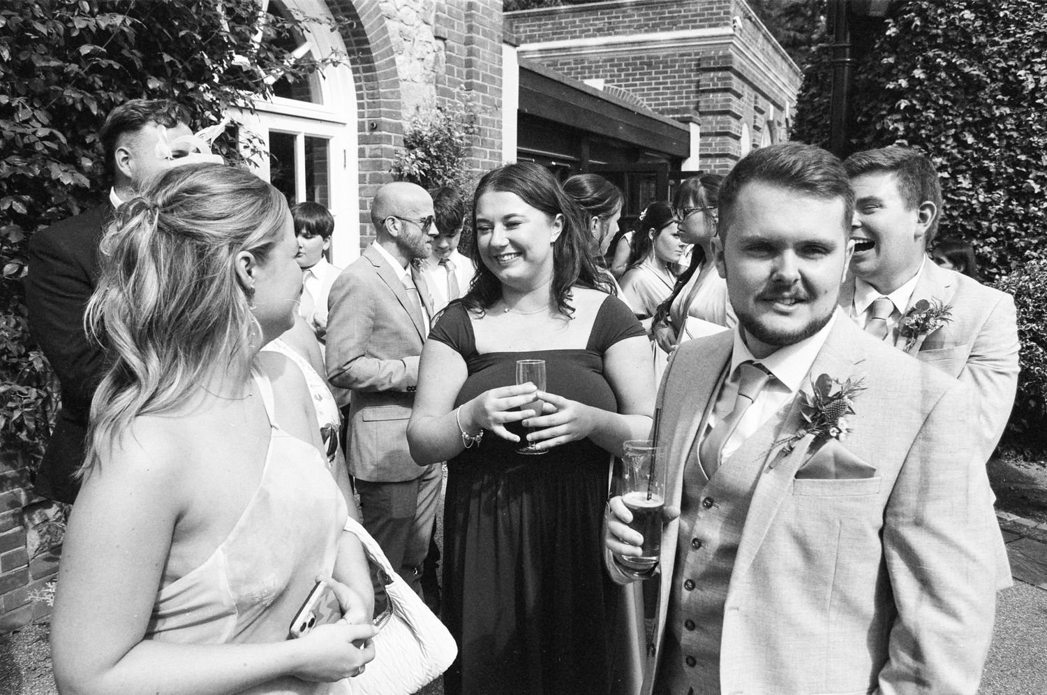 Wedding guests enjoying drinks and conversation in an elegant garden setting.