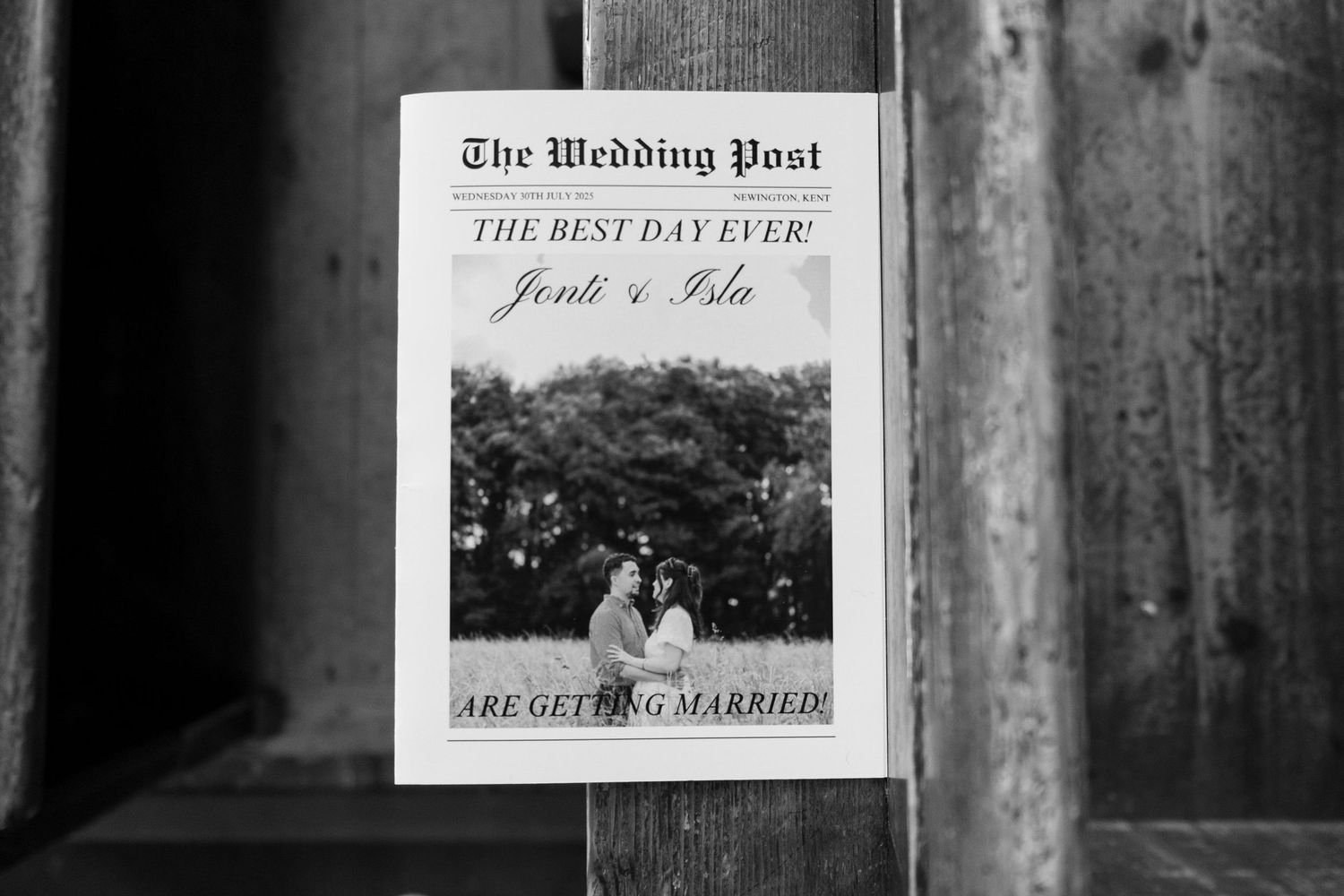 Black and white wedding program titled 'The Wedding Post' displayed against a dark background.