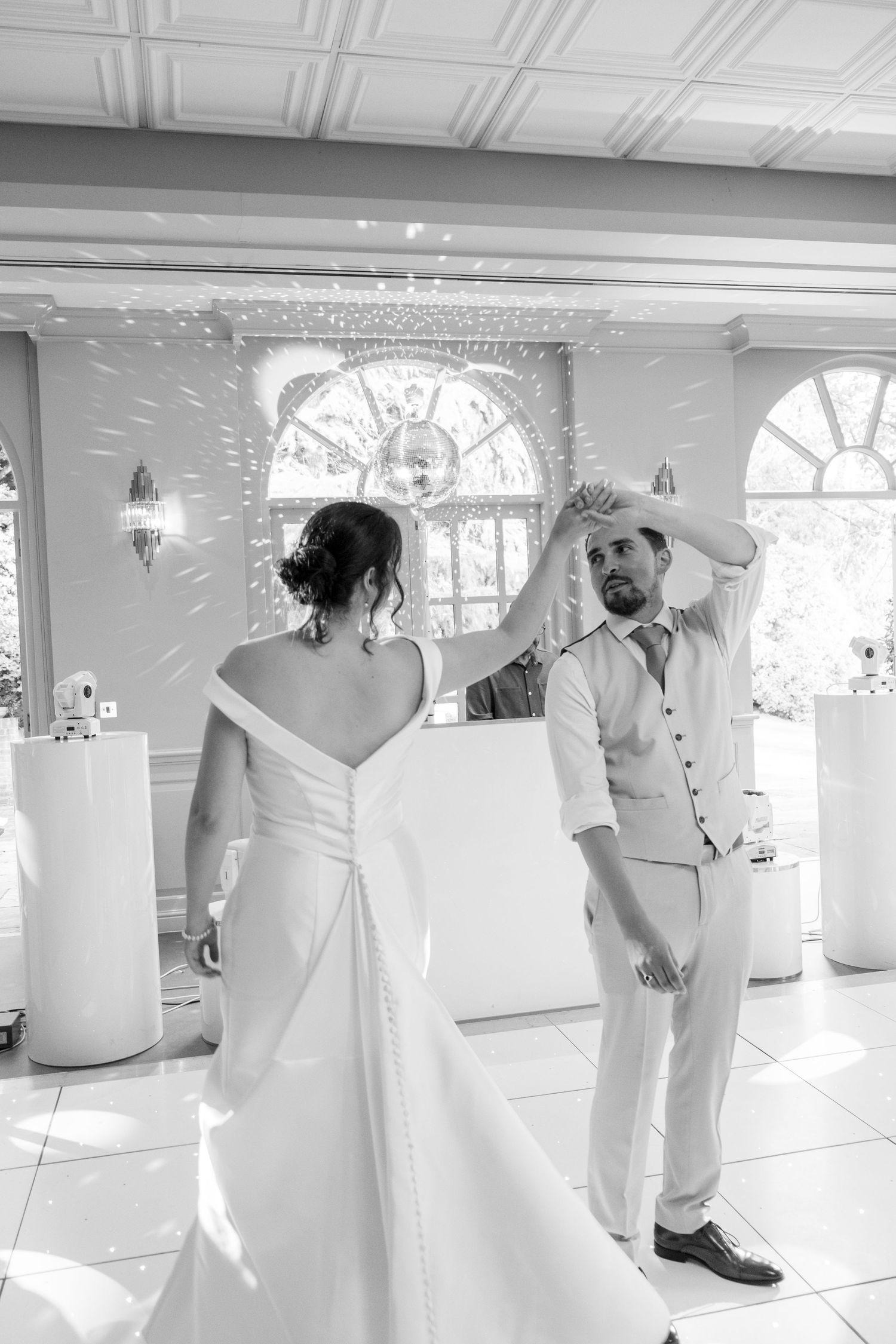 Wedding dance sequence in bright white ballroom showing flowing movement and joy.