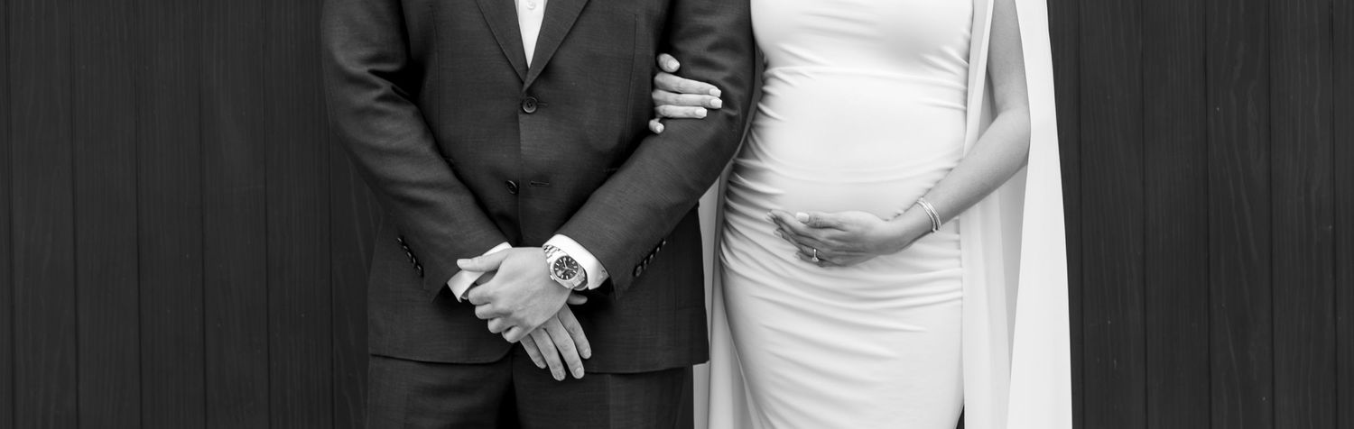 Black and white wedding portrait showing couple in formal attire with elegant poses.
