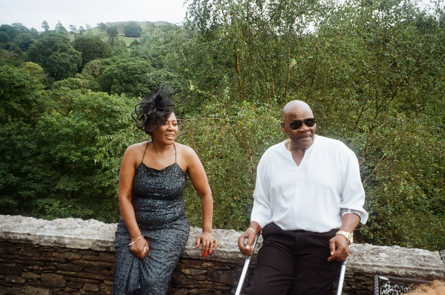 Wedding guests seated on rustic wooden benches in a natural outdoor setting.