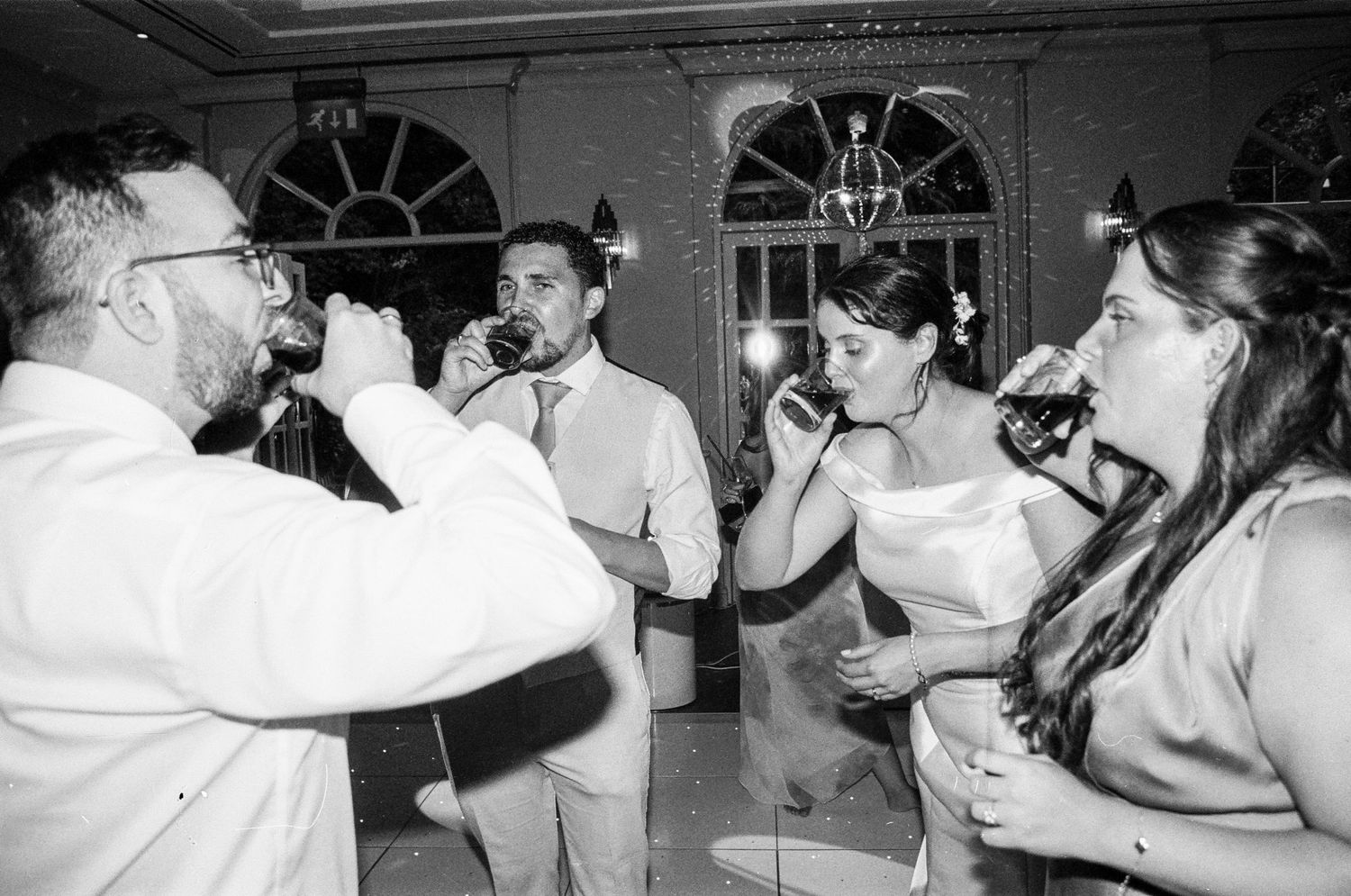 Wedding guests dance and celebrate at an elegant indoor reception venue.