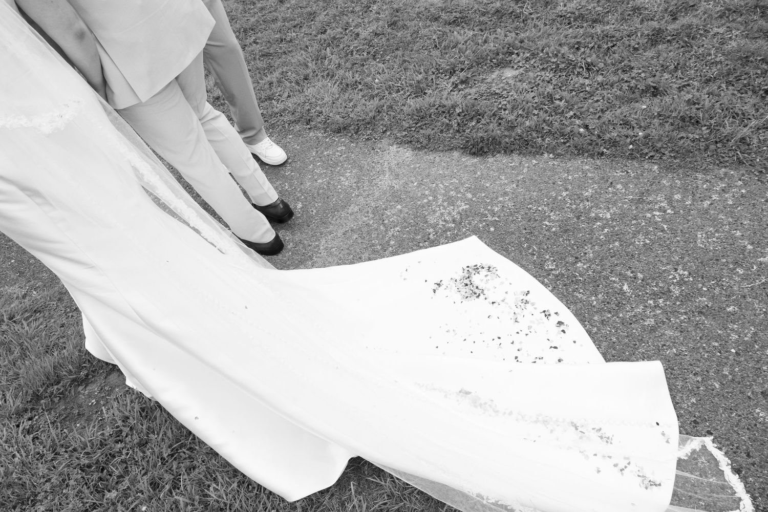 Wedding ceremony details showing rings and white fabric in an artistic black and white composition.