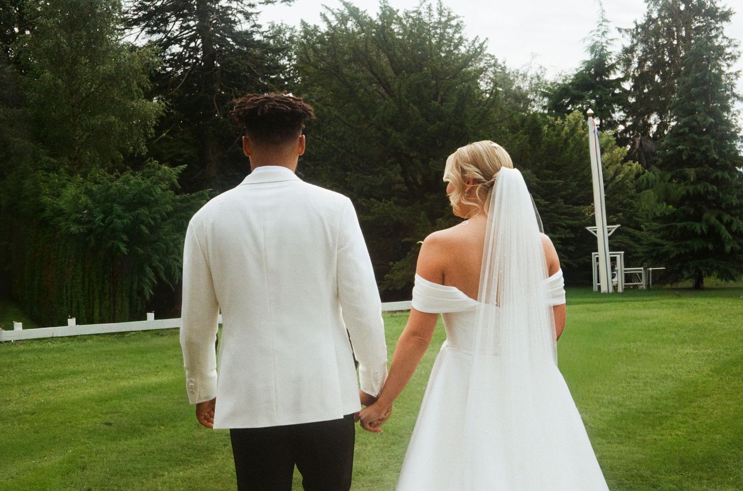 Wedding couple walking through a serene garden path during their celebration.