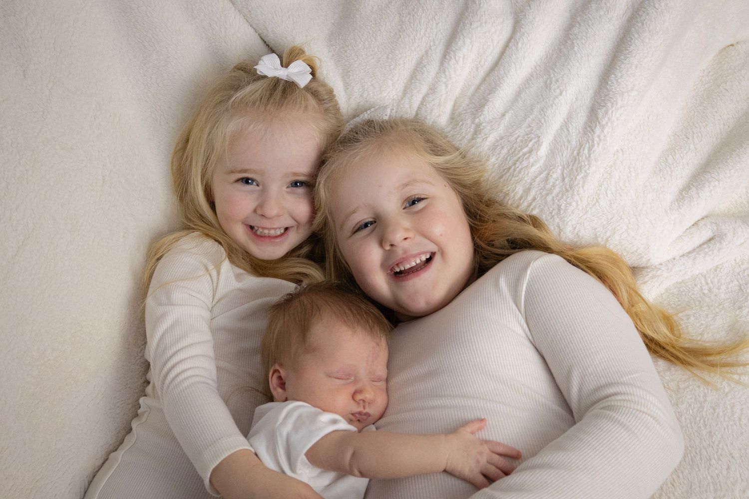 Siblings Cuddled on a sofa.