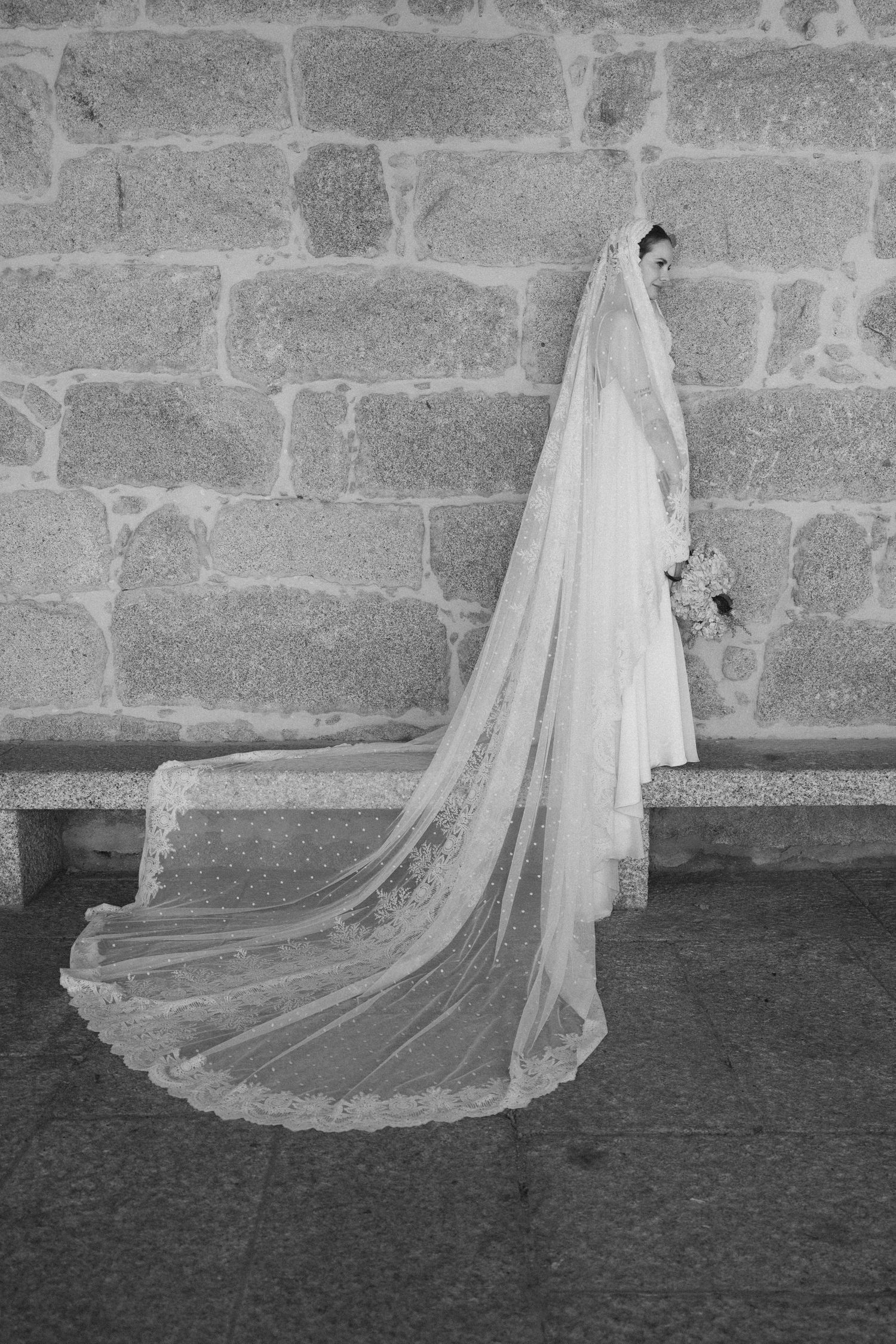 Black and white photos of flowing wedding veil against stone wall texture.