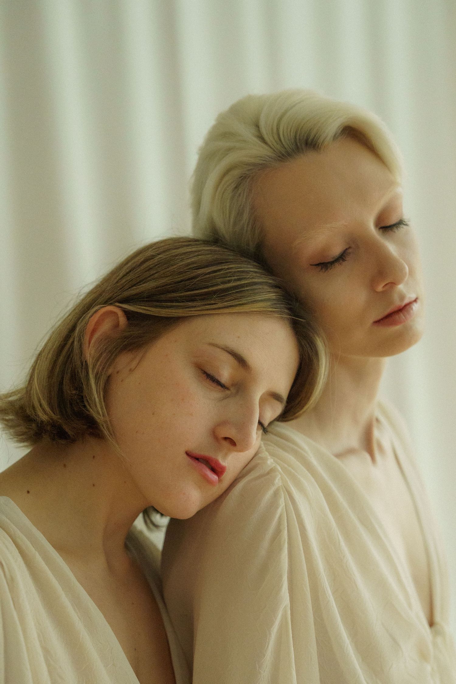 Ethereal portrait in soft lighting against white fabric backdrop.