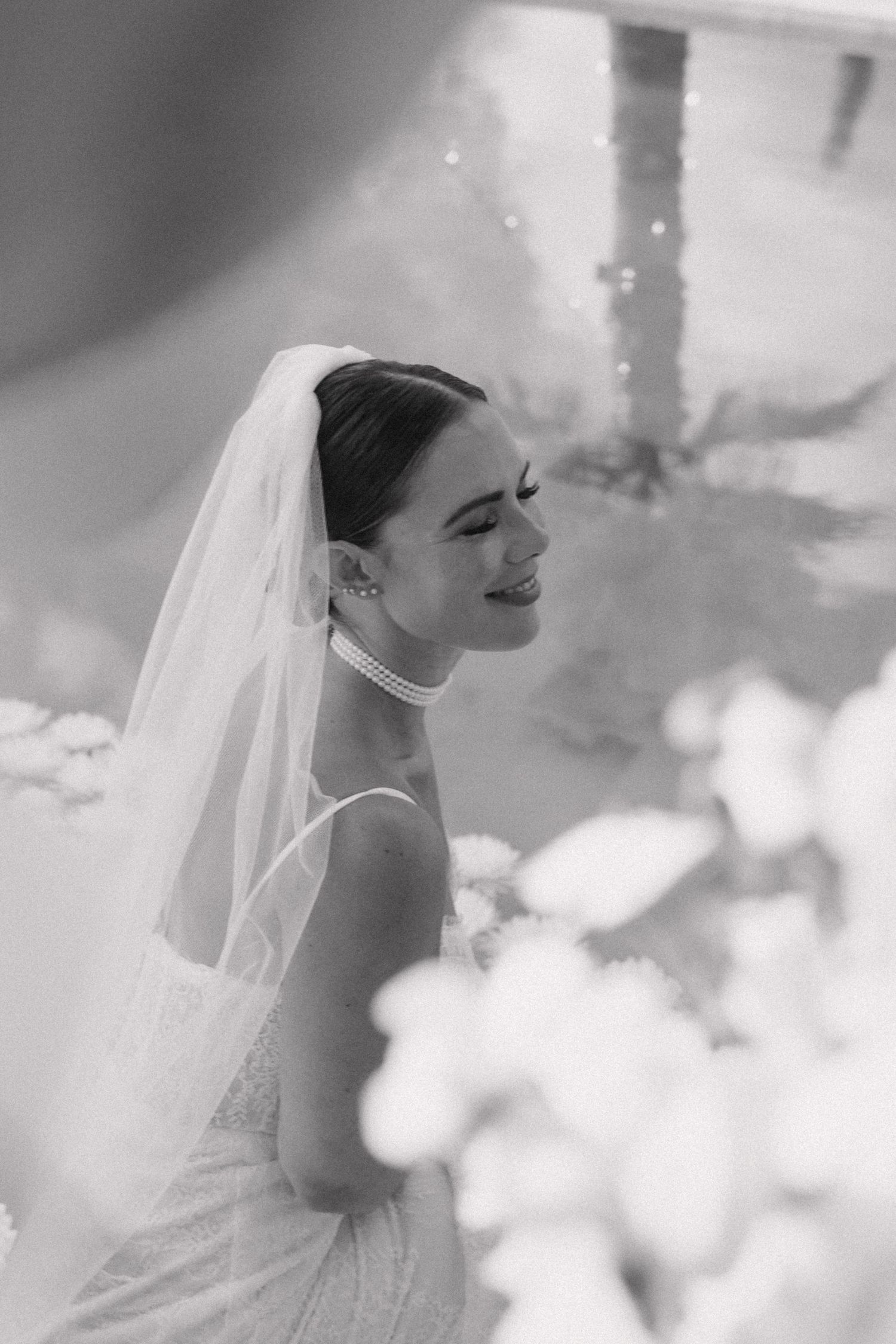 A black and white series of profile portraits showing a bride in a veil looking upward with a joyful expression.