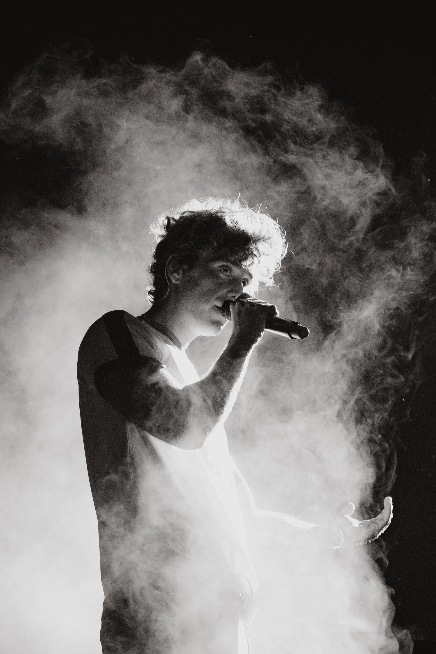 Silhouette of performer in smoke against dark background.