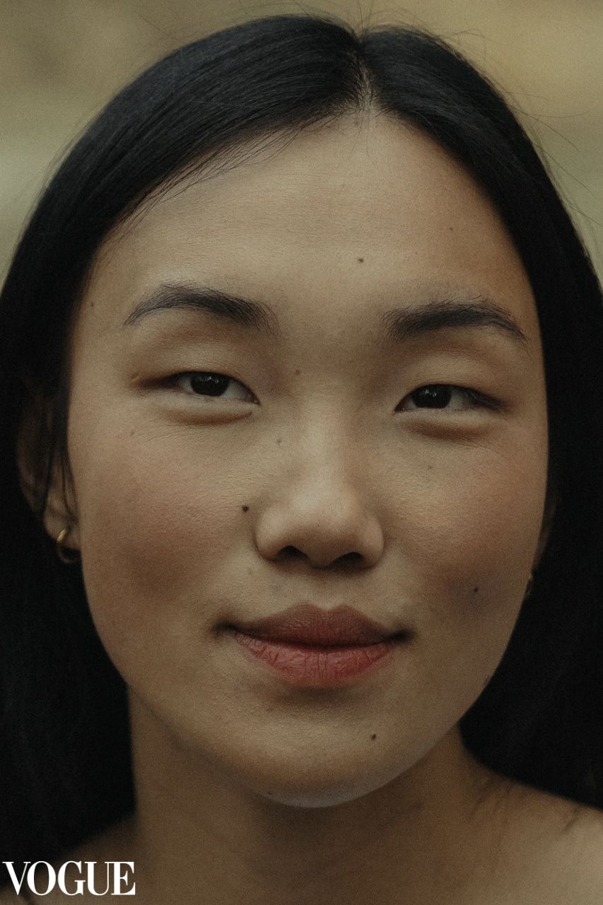 Close-up fashion portrait with natural makeup and soft lighting for Vogue magazine.