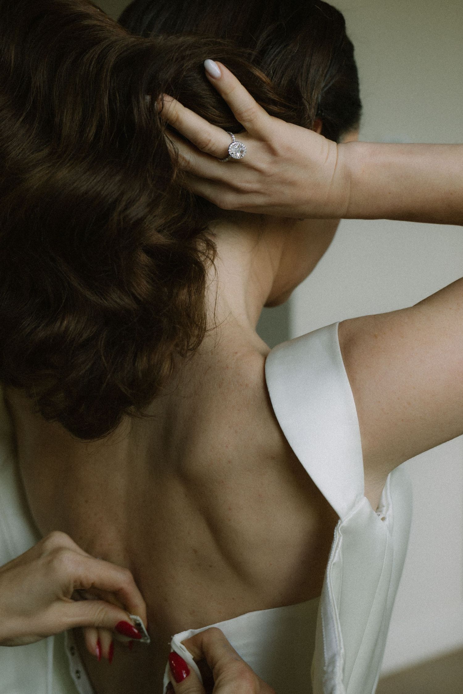 Artistic close-up shots of a white dress neckline and delicate jewelry details.