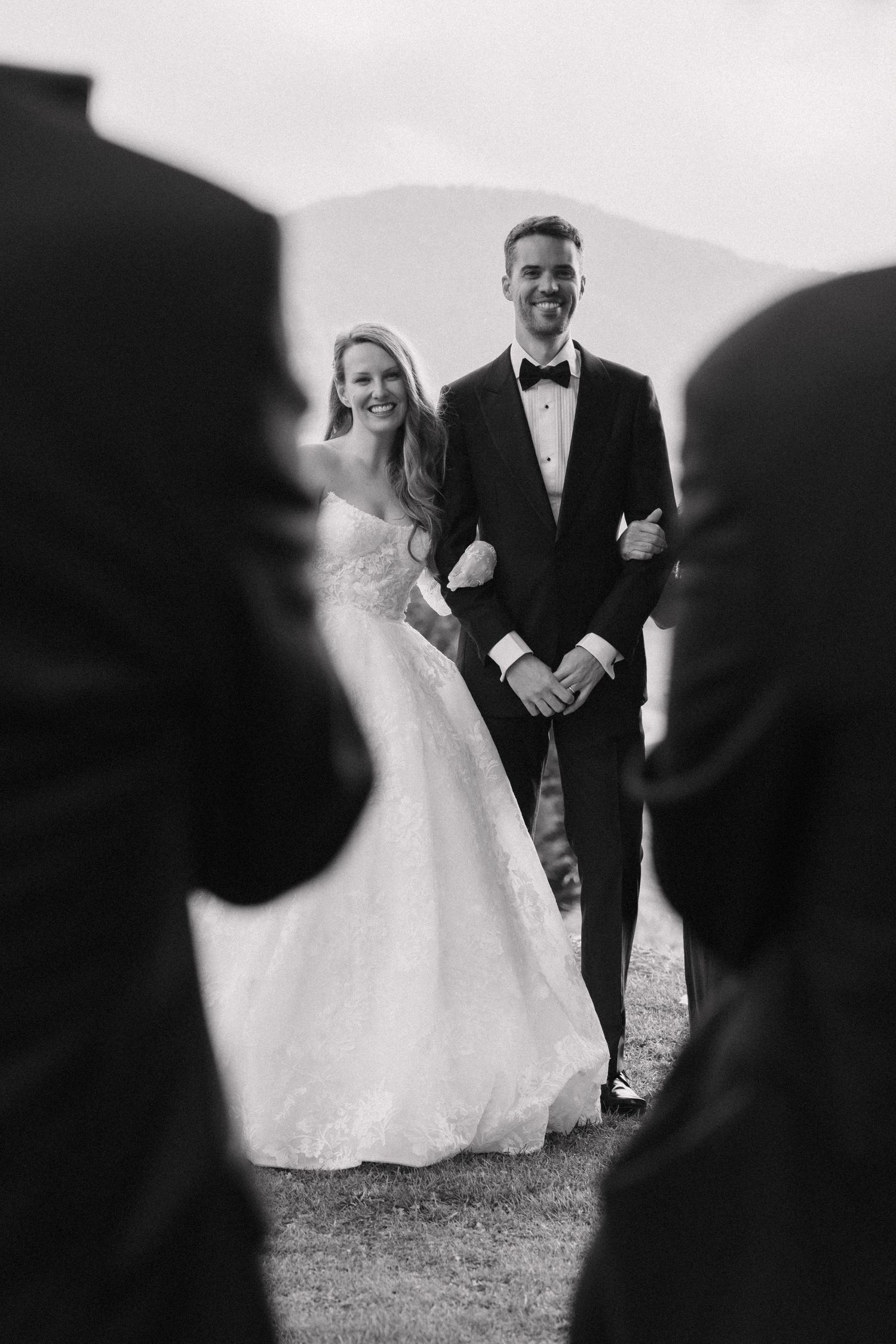 Black and white wedding photography captures candid moments between bride and groom outdoors.