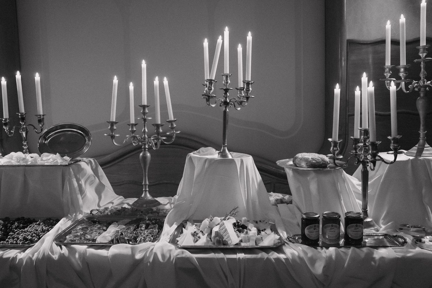 Elegant white candles in silver candelabras create a romantic wedding reception atmosphere.