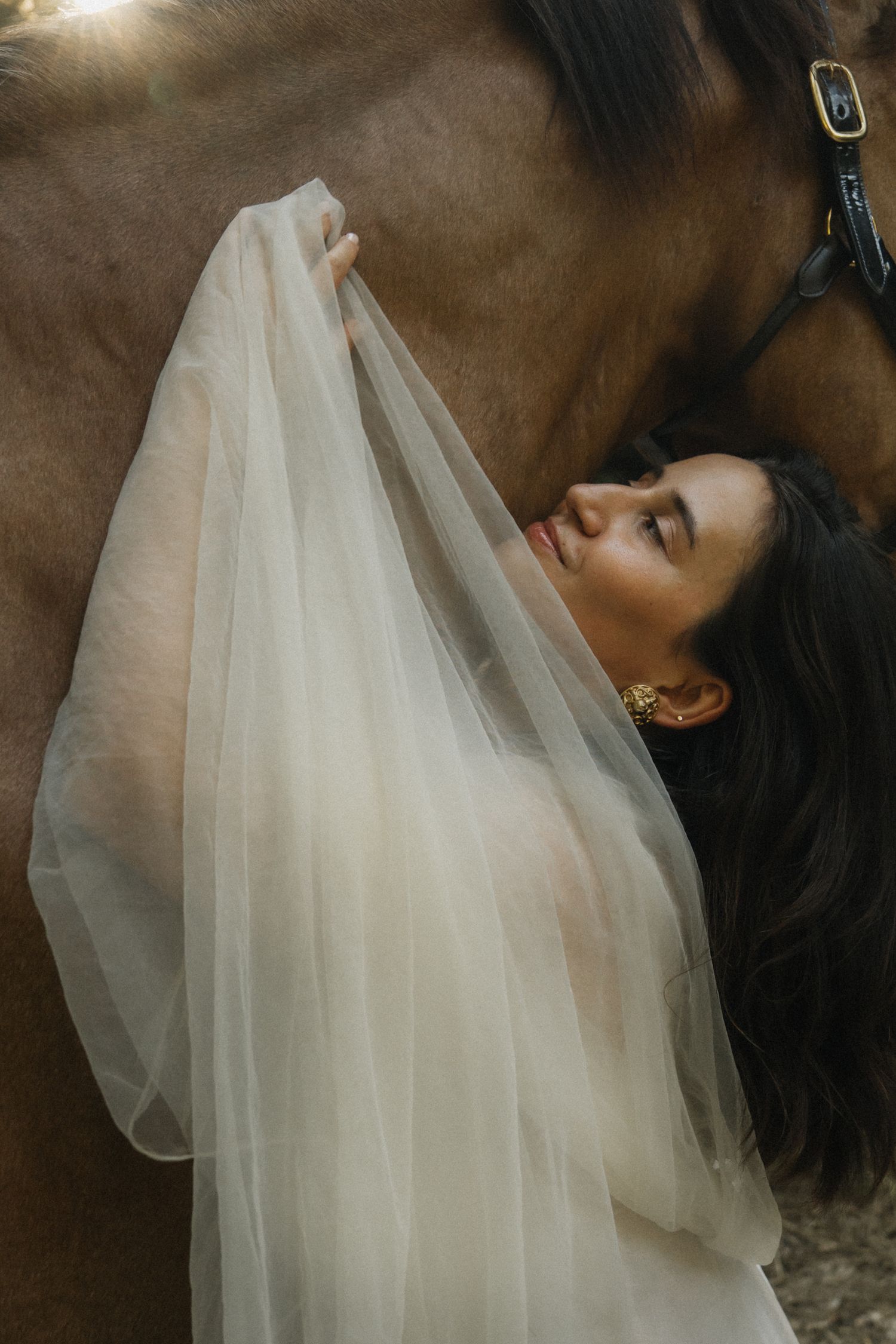 Ethereal bridal portrait with flowing white veil creating a dreamy atmosphere.