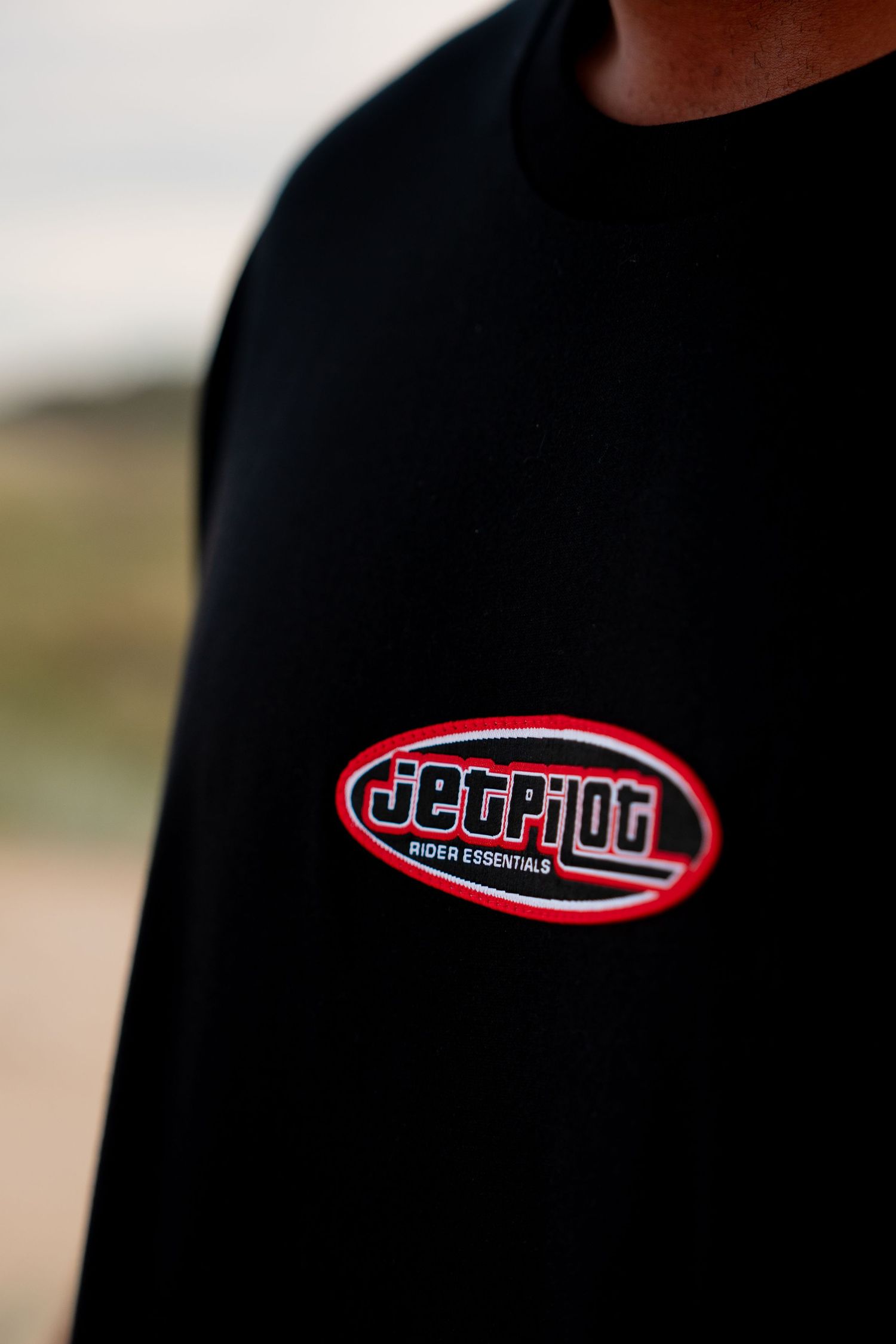A close-up view of a black t-shirt with a red and white Berghain logo design.