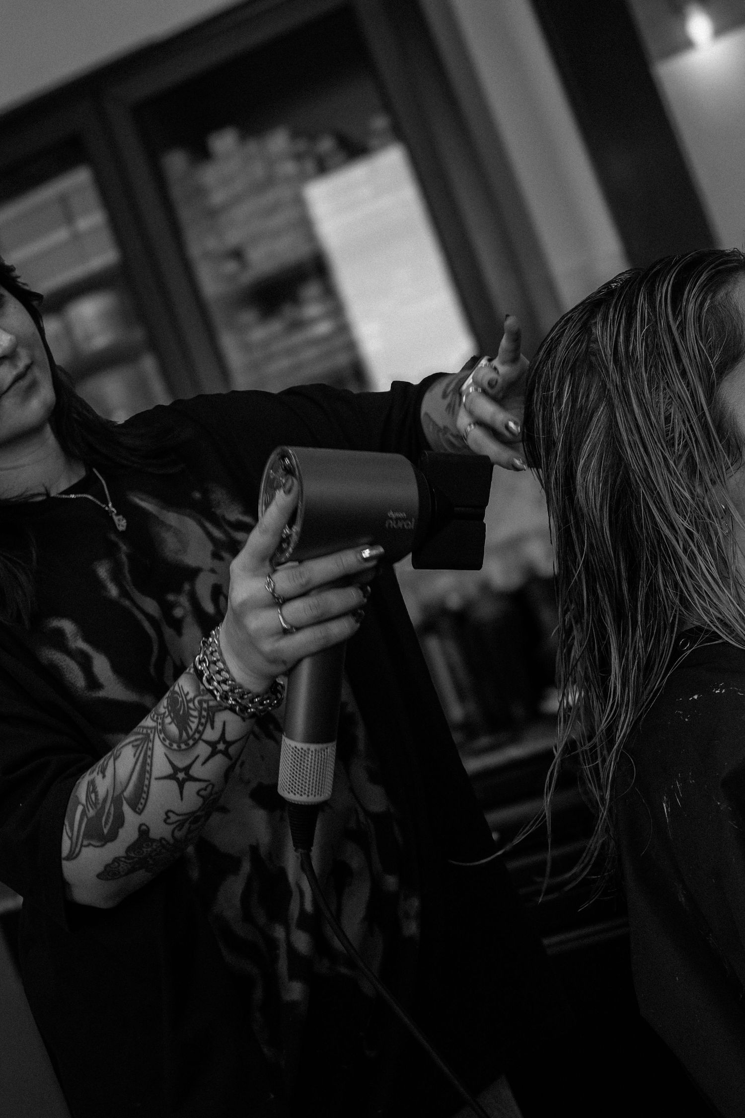 Black and white photo of hair styling session in salon.
