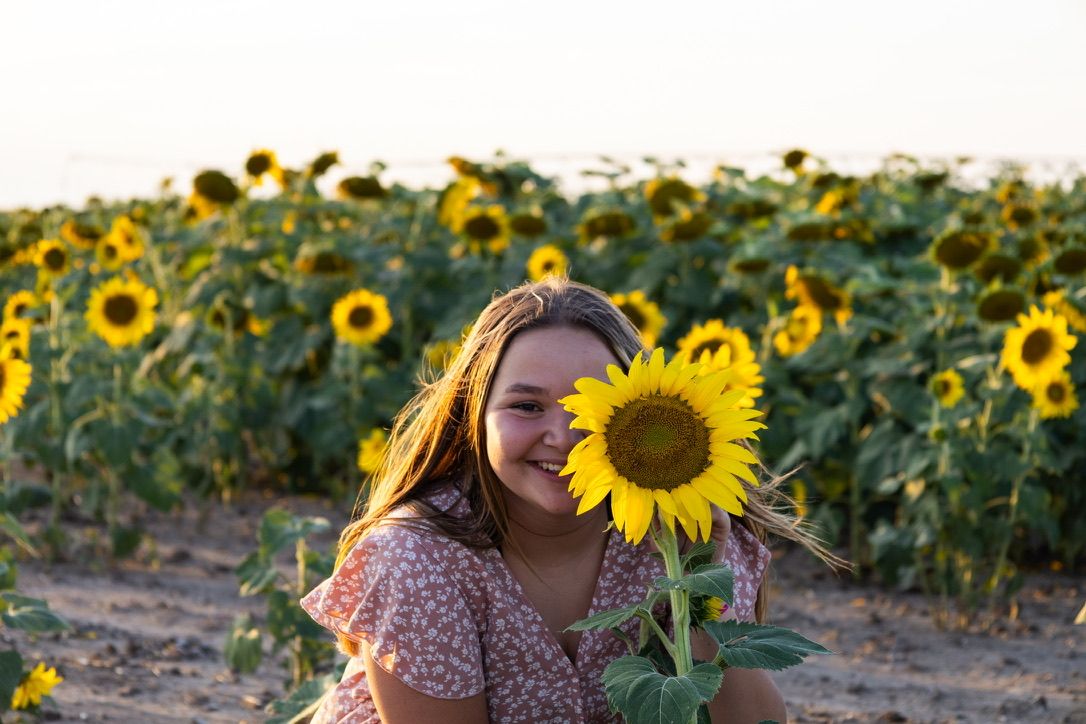 Girl behind sunflower