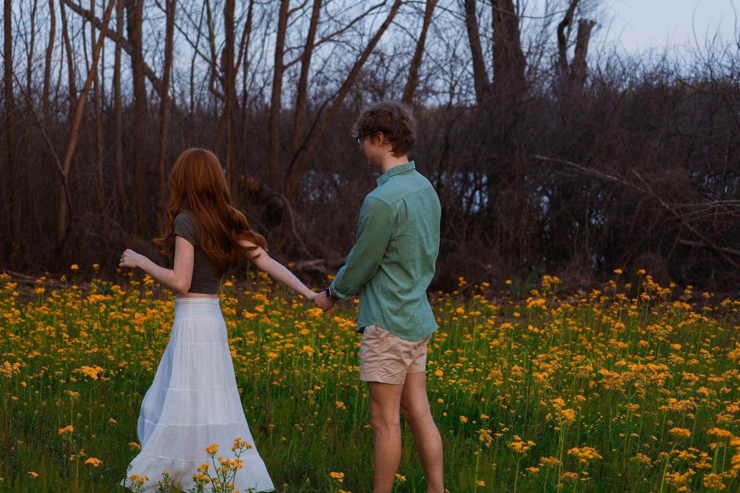 A couple running through the grass