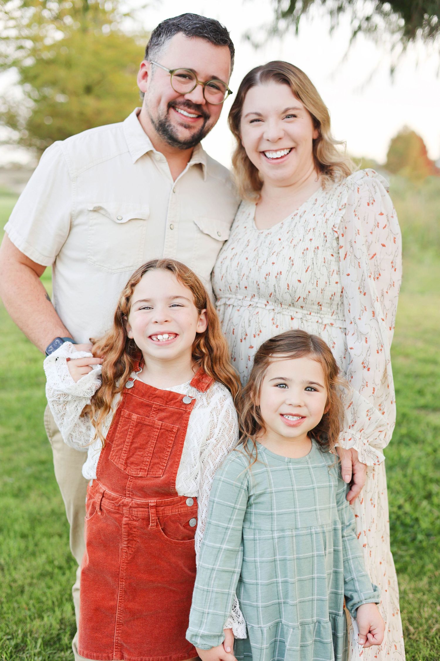 Family of four photo posed in nature park near lake.