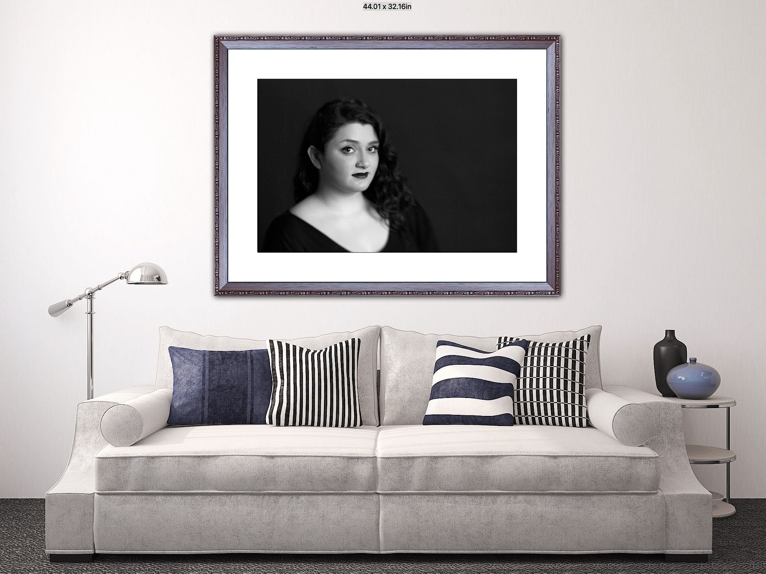 Modern living room interior with white sofa, striped pillows and framed artwork on wall.