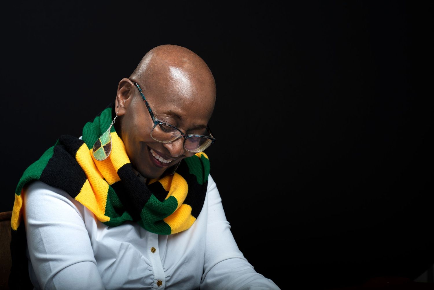 Portrait series showing person in yellow and green scarf against black background.