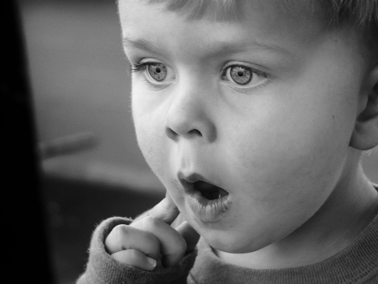 Close-up black and white portraits of young child with expressive eyes.