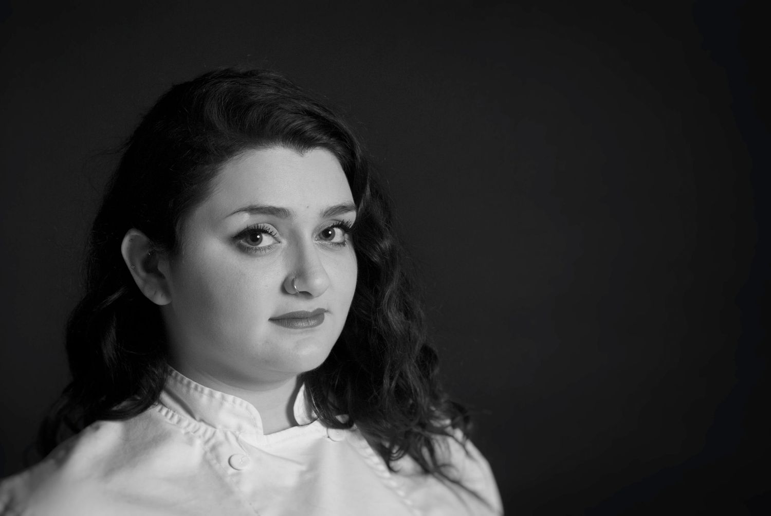 Dramatic black and white portrait of young woman with Vchef's jacket