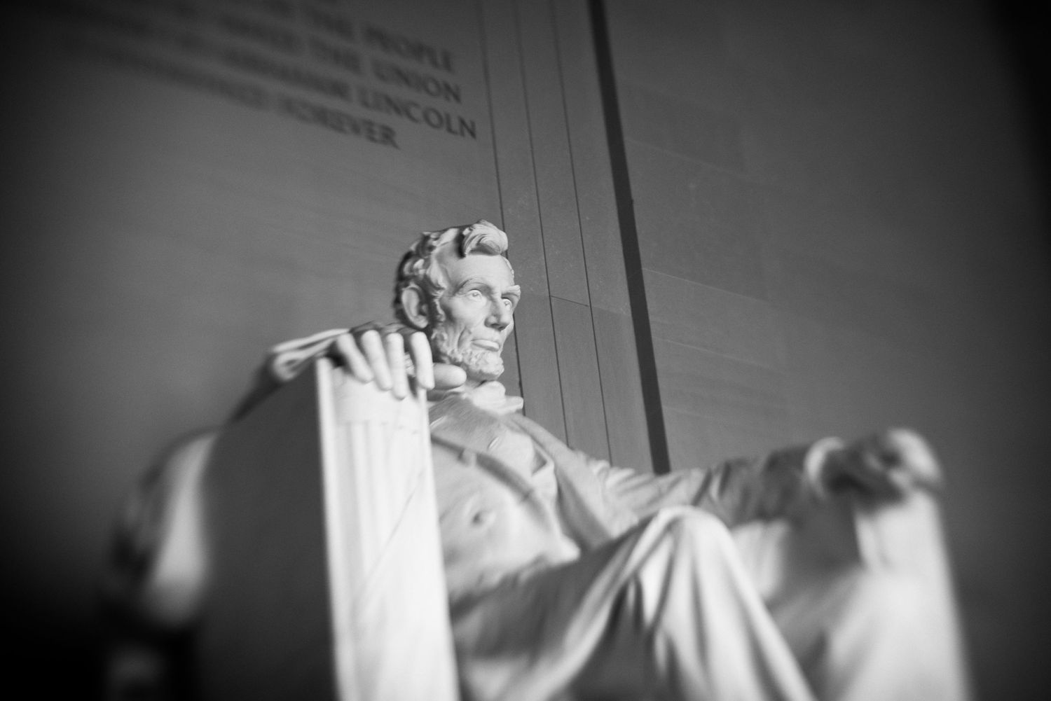 Black and white low angle photo of the iconic Abraham Lincoln Memorial marble statue in Washington DC.