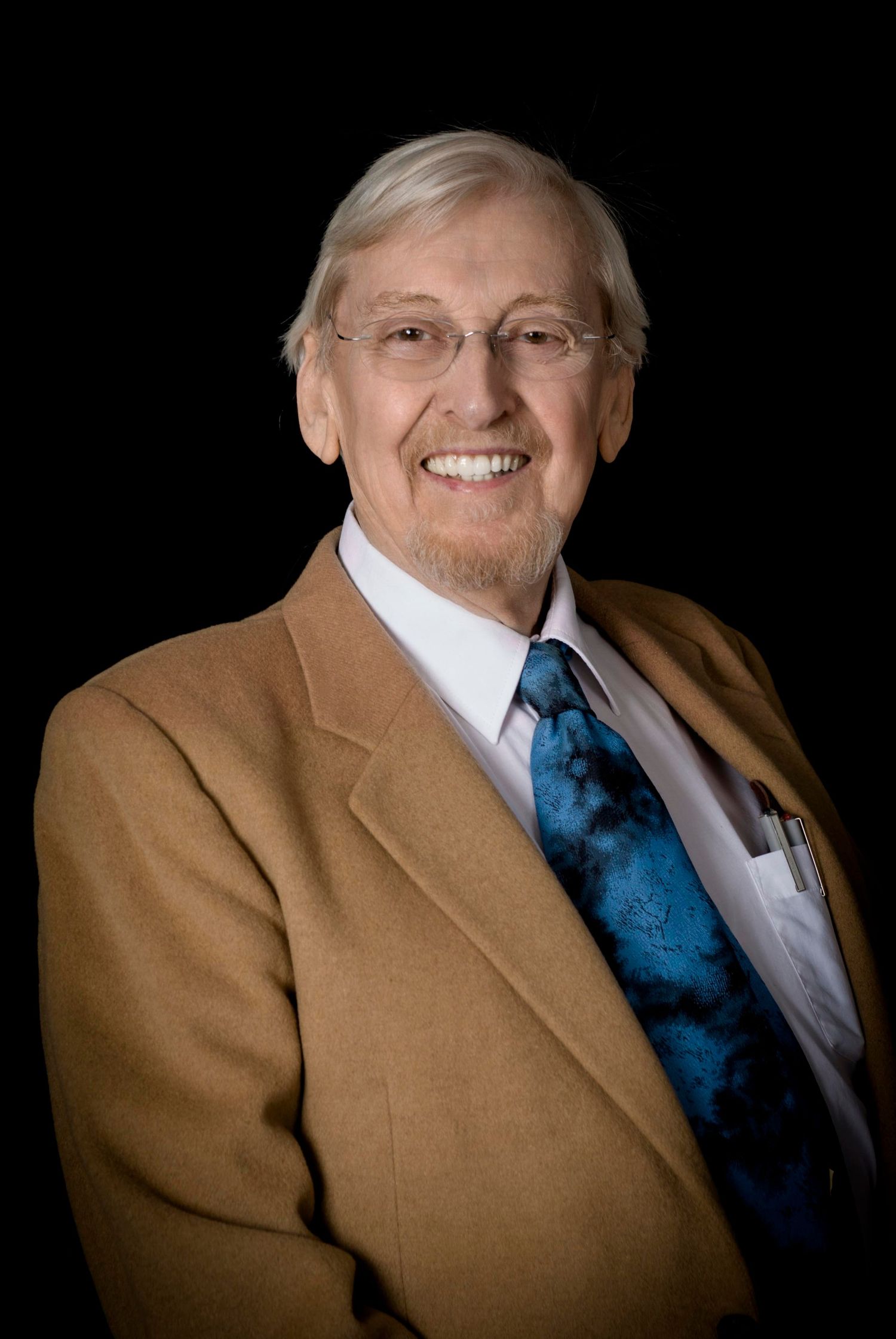 Professional portrait in tan suit and blue tie