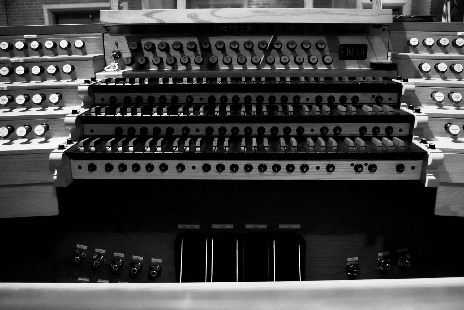 Pipe organ console at Christ Church Kensington, with multiple rows of stops and controls in black and white.