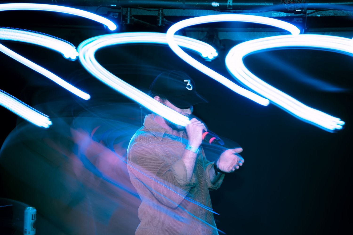Dynamic blue and pink light trails swirling through a black space.