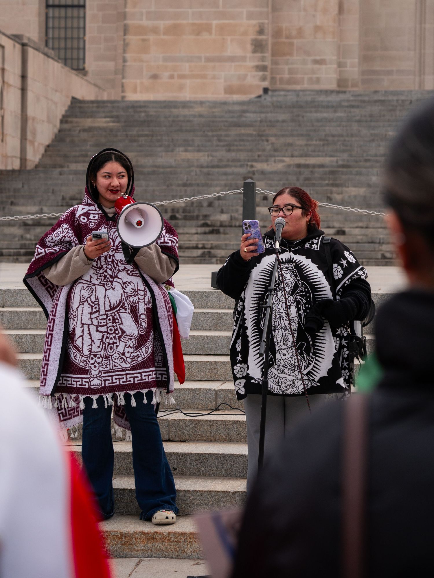 Group displays banners and signs during a protest demonstration at a public building.